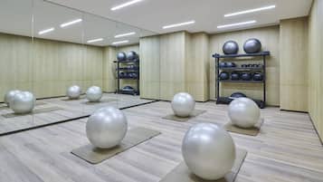 A gym with exercise balls on mats and a mirrored wall.
