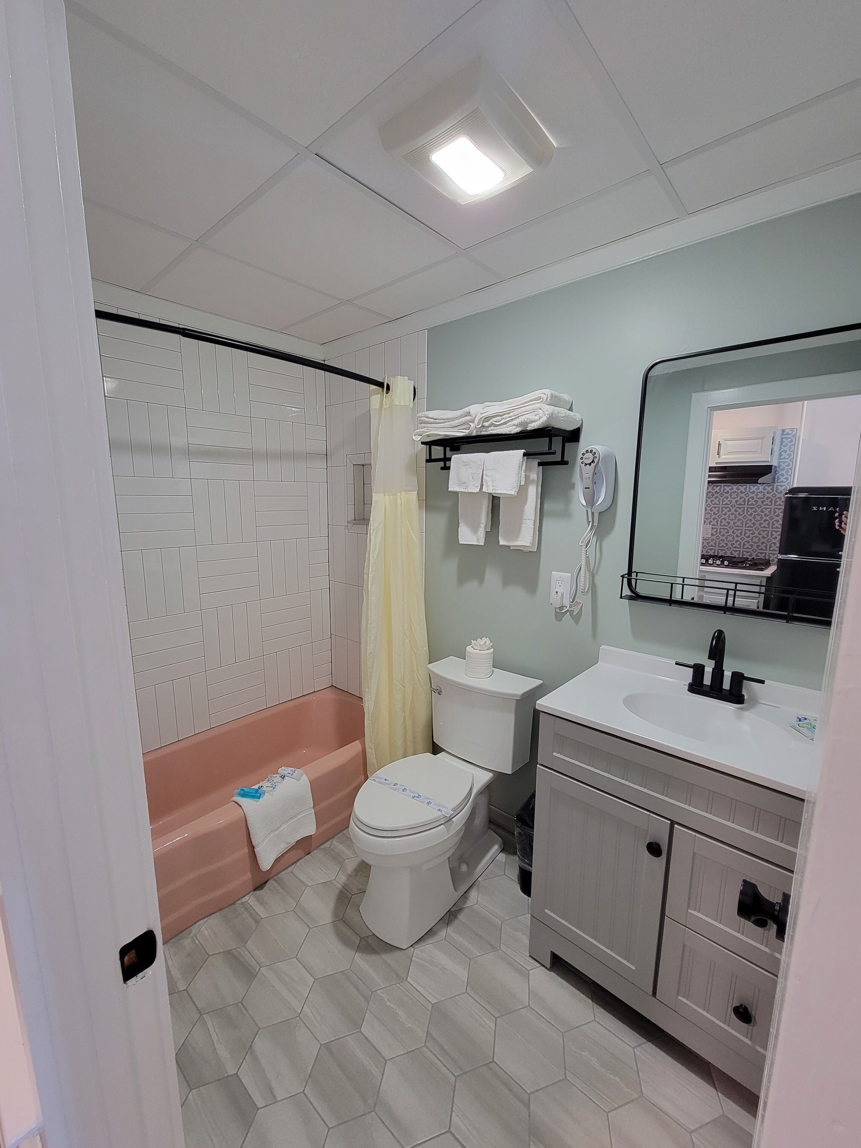 Une salle de bain comprenant des toilettes, un lavabo et une douche.