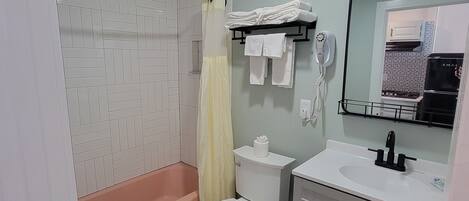 Une salle de bain comprenant des toilettes, un lavabo et une douche.
