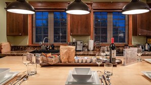 A kitchen with wooden cabinets, a marble countertop, and three pendant lights. - Mountain Studio - luxury finishes in upscale neighborhood, e-bikes included! (Bozeman)