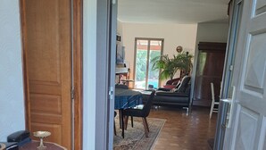 Un pasillo con piso de baldosas que lleva a un comedor con una mesa y sillas.