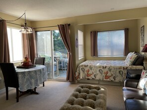Una camera da letto con un letto, una sedia, un tavolo e una finestra.