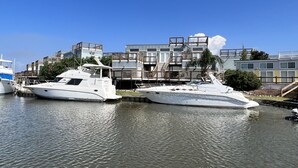 Two yachts docked at a marina with modern buildings in the background. - New Orleans RV Resort & Marina (New Orleans)