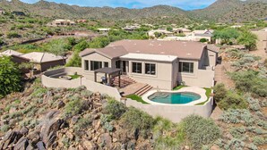 A modern house with a swimming pool, surrounded by rocky terrain and sparse vegetation. - Enjoy quality time in beautiful Fountain Hills at the coziest home (Fountain Hills)