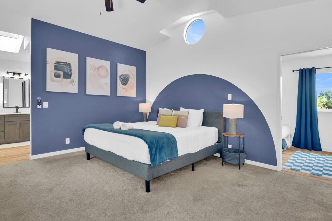 Une chambre à coucher moderne, avec un lit, des tables de chevet et des œuvres d’art accrochées aux murs.