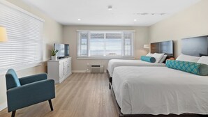 Una habitación de hotel moderna con dos camas, un escritorio y una silla.