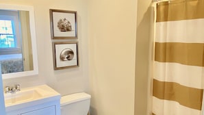 Un baño con inodoro, lavamanos y cortina de ducha.
