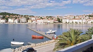 Uma cidade costeira com um porto, barcos e edifícios ao longo da orla marítima.