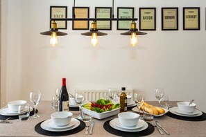 A dining table set with plates, bowls, cutlery, glasses, and a bottle of wine, with framed musical scores on the wall. - Stunning St James by the Quay
Harbour Life! (Ilfracombe)