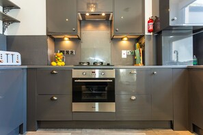 A modern kitchen with a built-in oven, stainless steel cabinets, and a toaster. - Stunning St James by the Quay
Harbour Life! (Ilfracombe)