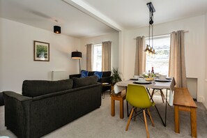 A modern living room with a sofa, dining table, and chairs. - Stunning St James by the Quay
Harbour Life! (Ilfracombe)
