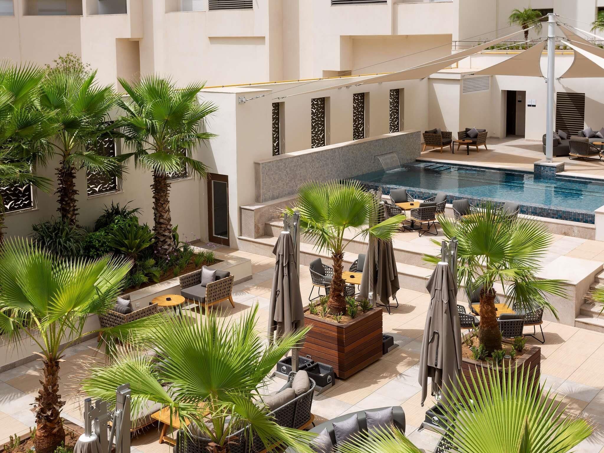 Una piscina al aire libre, sillones reclinables de piscina