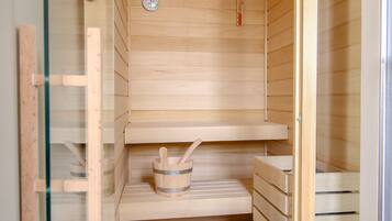 A sauna with wooden walls and a glass door, featuring a control panel, a small shelf, and a wooden bench.