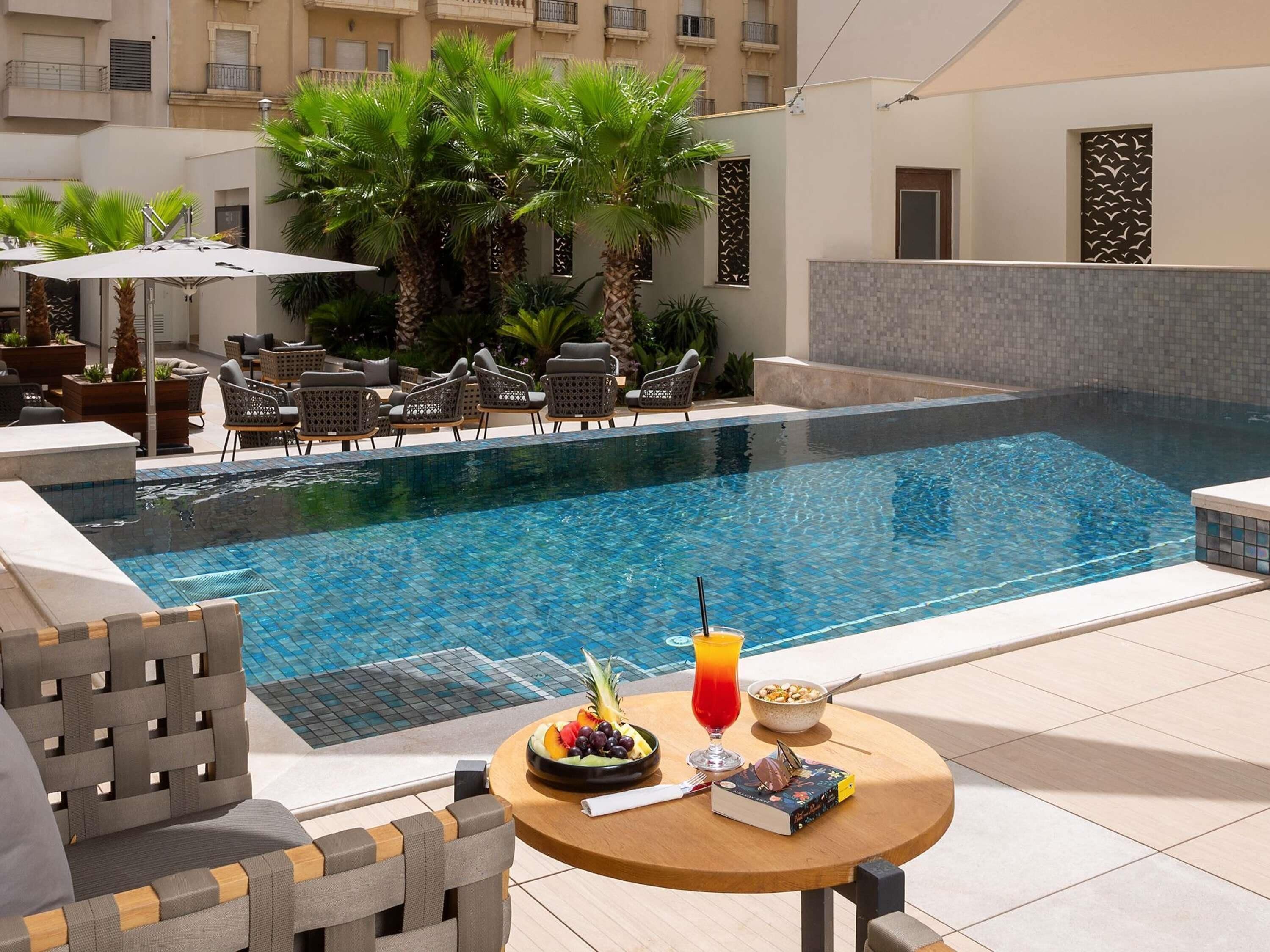 室外游泳池，開放時間為 09:00 至 17:00，提供日光浴躺椅