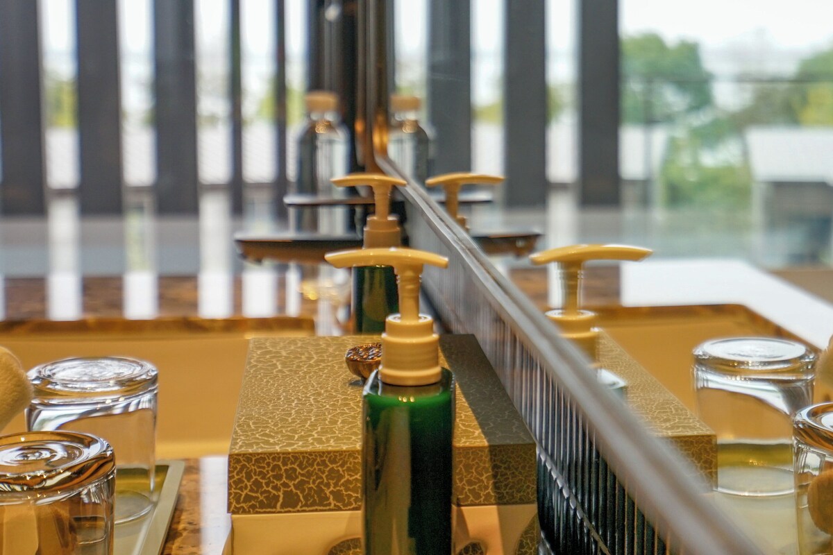 A bar area with a long counter, multiple bottles of beverages, and glasses.