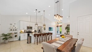 A spacious kitchen with white cabinets, a central island, and pendant lighting. - * Welcome to Relaxa * (Naples)