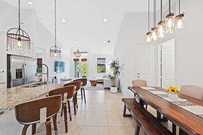 A modern kitchen with a central island, bar stools, and pendant lighting. - * Welcome to Relaxa * (Naples)