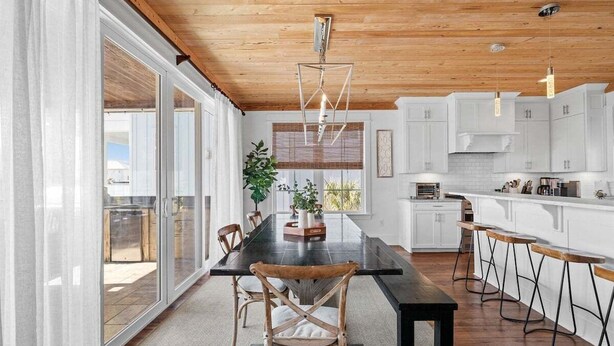 A modern kitchen with white cabinets, a black countertop, and a wooden ceiling. - 1 HOUSE OFF BEACH w/ LSV, BIKES, POOL & GULF VIEWS! PET FRIENDLY! (Santa Rosa Beach)