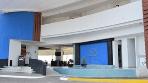 A hotel entrance with a blue facade, a reception desk, and a sign that reads "Park Royal." - Tasteful Junior Suite with a Terrace and Private Beach Area (Marina Mazatlán)