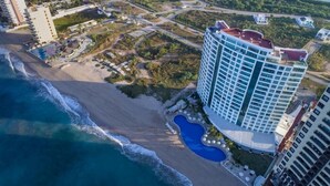 An aerial view of a coastal hotel with a large beachfront, a swimming pool, and high-rise buildings. - Private Junior Suite with a Short Ride Away from Beach (Marina Mazatlán)