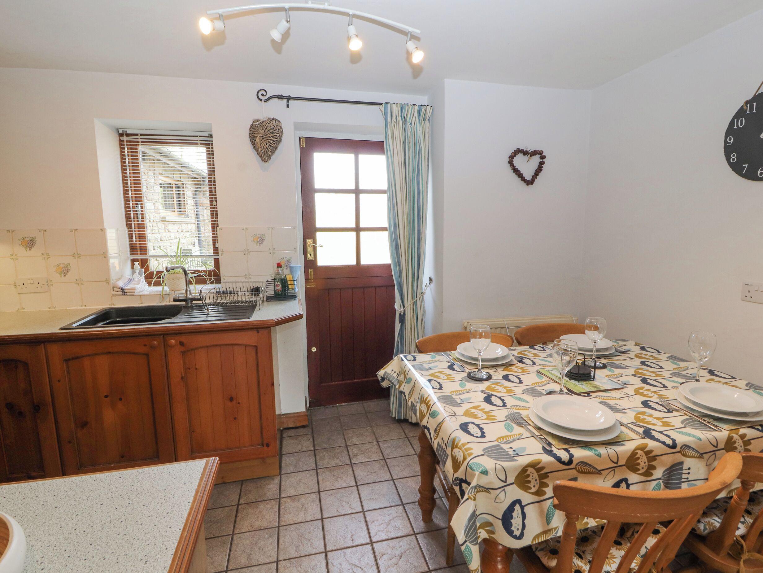 A kitchen with a wooden counter, a sink, and a dining area with a table set for four.