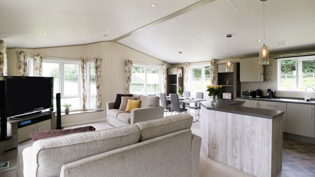 A spacious living area with a sofa, a TV, and a dining table. - Hill View, Lilac Lodge (Wareham)