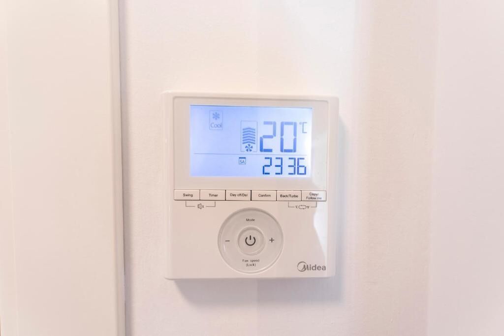 A digital thermostat with a display showing 20°C and 23.36.