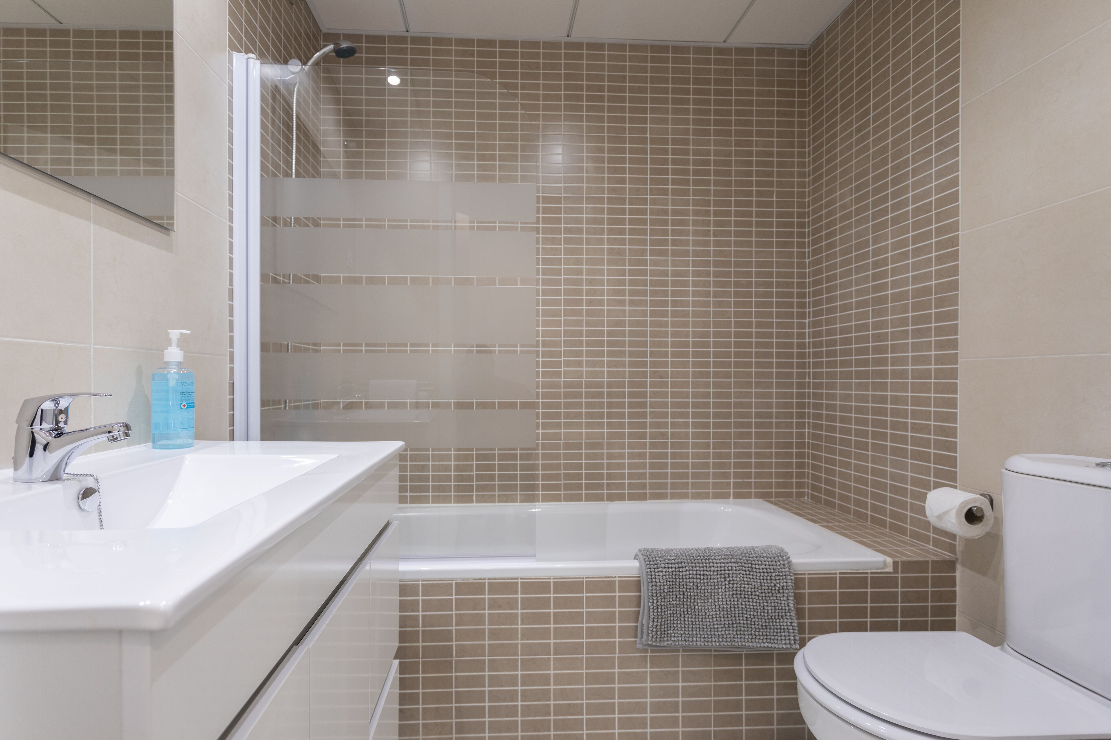 A bathroom with a white sink, a bathtub, and a toilet.