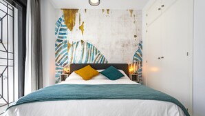 Une chambre moderne avec un grand lit, un mur décoratif et des lampes de chevet.