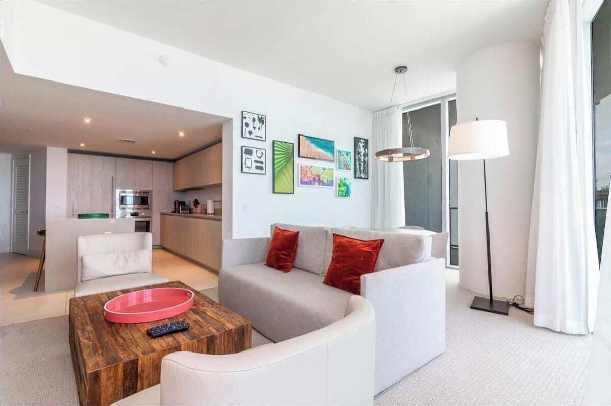 A modern living room with a sofa, coffee table, and artwork on the wall.