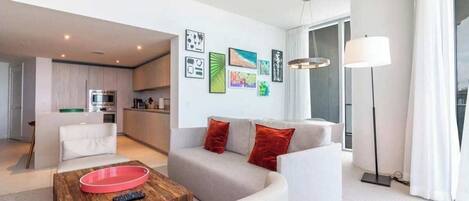 A modern living room with a sofa, coffee table, and artwork on the wall.