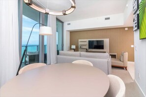 A modern hotel room with a round dining table, a sofa, a TV, and a balcony with a view. - Escape to Luxury! Hyde Resort : Ocean Views, Full Amenities & Unbeatable Price! (Hollywood)