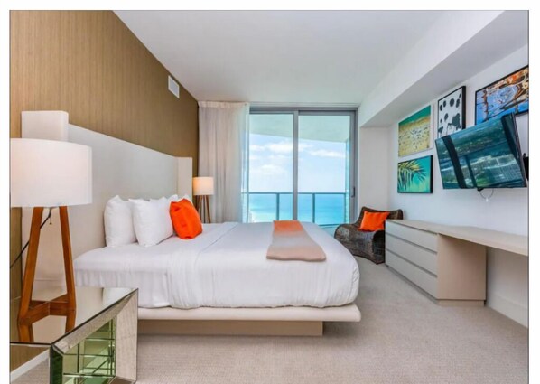 A modern hotel room with a large bed, a desk, and a view of the ocean. - Escape to Luxury! Hyde Resort : Ocean Views, Full Amenities & Unbeatable Price! (Hollywood)