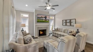 A living room with a fireplace, two sofas, a coffee table, and a ceiling fan. - Luxury in a Prime Folly Location! Walk everywhere! (Folly Beach)