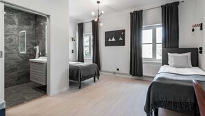 Un dormitorio moderno con una cama grande, una cama más pequeña y un vestidor.