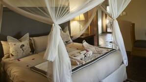 A bed with a canopy, pillows, and a bedside table with a lamp.