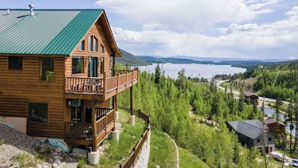 A wooden cabin with a balcony overlooking a lake and forested landscape. - Amazing Views of Shadow Mnt/lake,firepit,3br/2ba Cozy Cabin in Grand Lk,sleeps6 (Grand Lake)