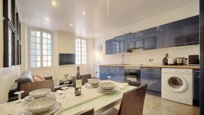 A modern kitchen with dark cabinets, a built-in oven, and a washing machine.