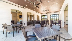 A spacious indoor dining area with multiple tables and chairs, high ceilings with exposed beams, and large windows allowing natural light. - New Listing! Windsor At Westside Resort, 8mi to Disney & 15mi to Universal - GRH438823 (Kissimmee)