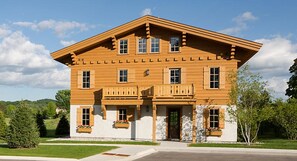 Stunning two-story house with a central entrance and two balconies, each with flower boxes.