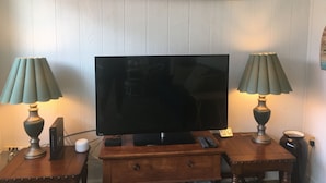 Un televisor sobre un soporte de madera con un letrero que dice "EAT.BEACH.SLEEP.REPEAT".