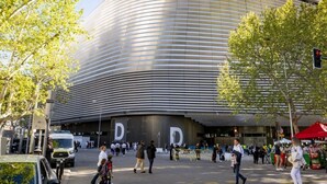 Een modern gebouw met een gebogen gevel en grote letters 'D' op het gelijkvloers.