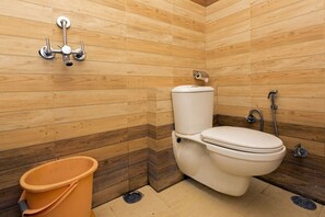 Un baño pequeño con inodoro, bidé y un cubo de basura.