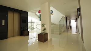 Ein modernes Interieur mit poliertem Boden, einer Treppe und Topfpflanzen.