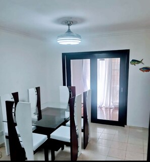 Enjoy meals in this cozy dining area with a wooden table and comfortable chairs.