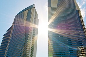 Two sleek high-rise buildings with a curved facade and horizontal lines create a striking architectural design.