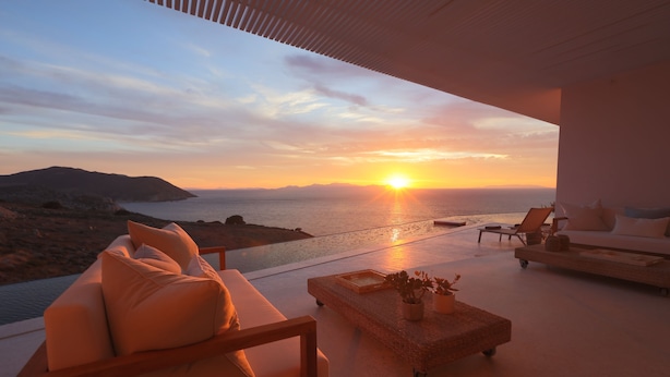 A modern outdoor seating area with a view of the sunset over the sea. - Luxurious Antiparos Villa with Infinity Pool and Stunning Sea and Sunset views (Antiparos)