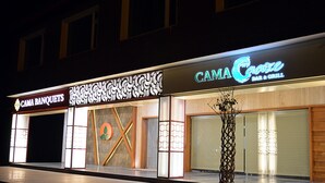 A building with a sign for "CAMA BANQUETS" and "CAMA Cafe Bar & Grill". - Cama Hotel (Mohali)