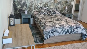 A bedroom with a bed, nightstands, a desk, and a chair.
