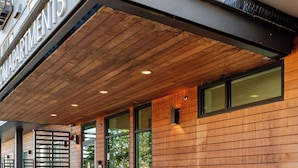 A building with a wooden facade, a sign reading 'apartments,' and a set of stairs leading to the entrance. - Beacon Hill 1BR - Rooftop + Patio - Near VA Medical - Monthly Stays (Seattle)